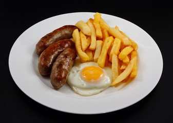 Close up of Sausage, egg and chips.