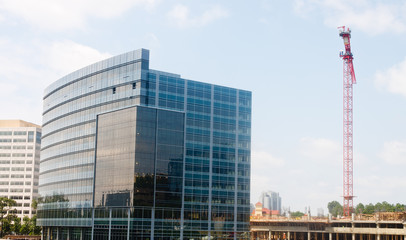 New Glass Building by Construction Site with Red Crane