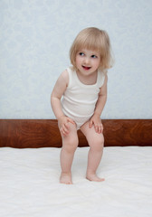 Fototapeta premium Baby is jumping on the bed