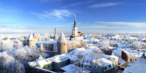 Panoramic aerial view of the old town of Tallinn, Estonia. St. Olaf's Church, fortress towers, snow-covered roofs and spires. Winter, Christmas vacations, travel destinations, sightseeing, culture - obrazy, fototapety, plakaty