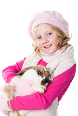 cute teen girl in winter outfit holding rabbit isolated on white