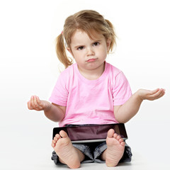 Clueless looking little girl sitting on the floor with touchpad
