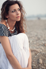 Fototapeta na wymiar pensive brunette woman sitting on coast