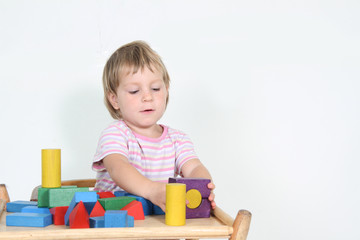 cute child playing with building blocks isolated over white