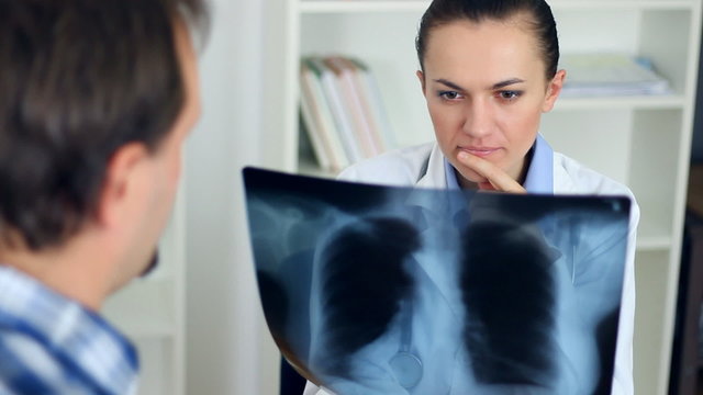 Female doctor in the office looking at xray of human lungs