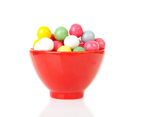 bowl with colorful gumballs over white background