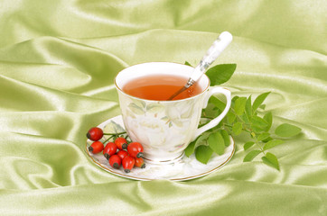 Rosehip tea, green background, satin