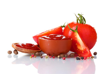 Ketchup dans un bol, épices et tomates isolated on white
