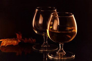 Two wineglasses and Autumn leaves on the mirror