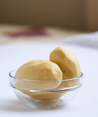 peeled potato in a glass bowl close up