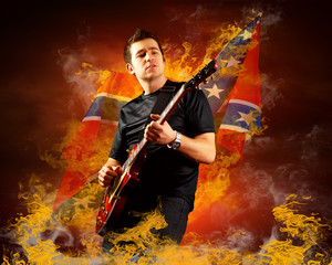 Obraz na płótnie Canvas Rock guitarist play on the electric guitar around fire flames