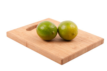 Two ripe limes on wood