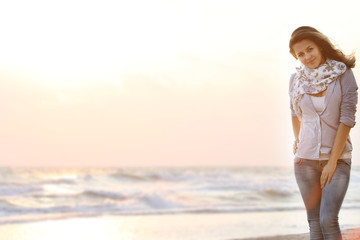 Fototapeta premium young attractive woman on sunset sea background