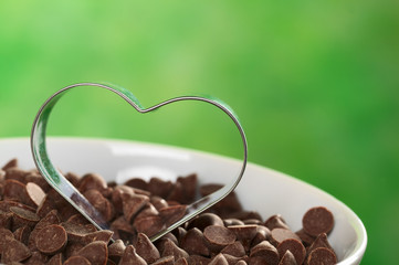 Heart-shaped cookie cutter on chocolate chips - Powered by Adobe