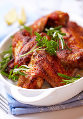 Roasted chicken wings with rosemary in a white dish