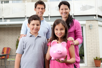 Little girl with her family holding a piggy bank