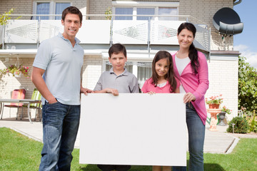 Young family holding a black white board