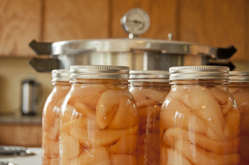 Glass jars of pears with a pressure cooker