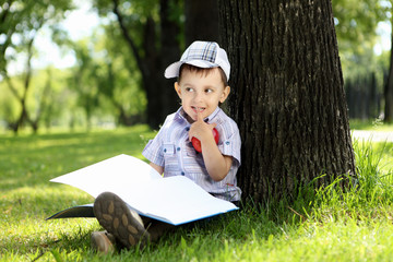 Portrait of a boy with a book in the park