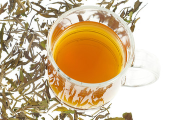 tea in glass cup and dried leaves