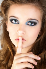 Naklejka premium Bright picture of young woman with finger on lips.