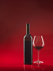 bottle of wine, glass on red background