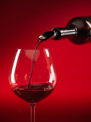 wine being poured in glass red background