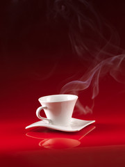 white cup of coffee on red background
