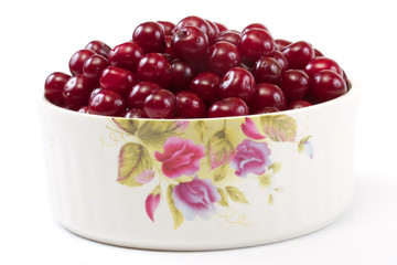 Bowl with ripe cherries. Isolated on a white background.