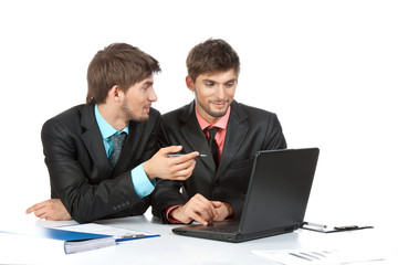 Two business people in elegant suits sitting at desk working