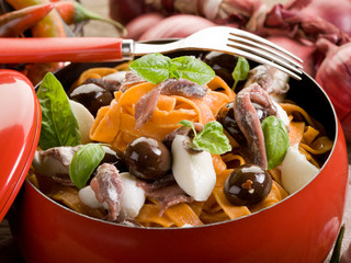 red tagliatelle with mozzarella, anchovies and black olives