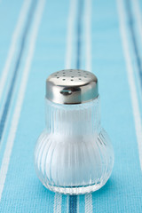 Salt shaker on a blue tablecloth