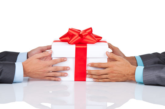 Businessmen hands at the desk holding gift box isolated
