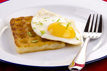 Waffel mit Spiegelei auf einem weißen Teller