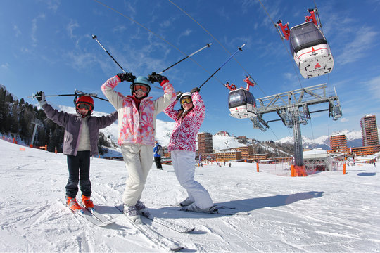 Trois jeune skieur devant les télécabines