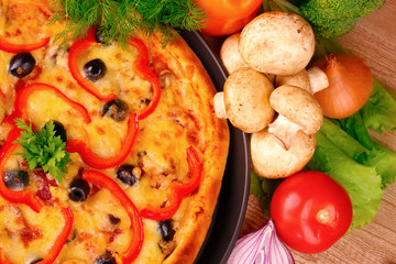 tasty pizza with olives and vegetables on a wooden background