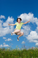 Girl jumping, running against blue sky