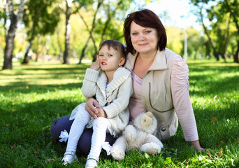 Obraz premium Grandmother with her little granddaghter in park