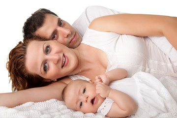 Sweet young family lying together on bed