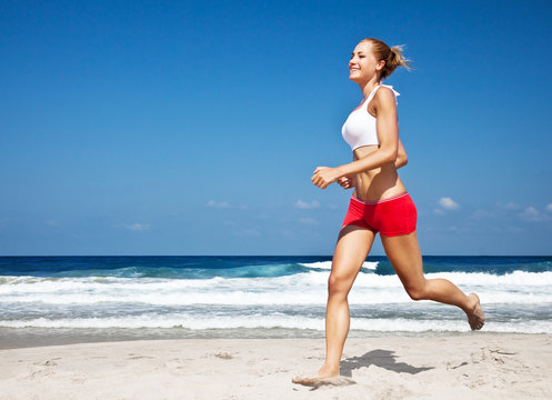 Healthy Woman Running On The Beach