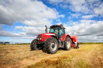 Papier Peint photo Tracteur tracteur ramassant la botte de foin sur le terrain, technique de panoramique