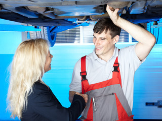 Motor mechanic shaking hand with a customer in a garage