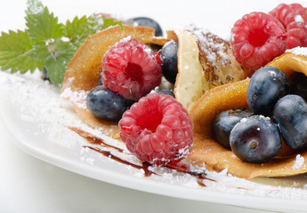 pancakes topped with blueberries,raspberries, mint and powdered