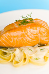 Salmon steak on pasta, decorated with dill closeup