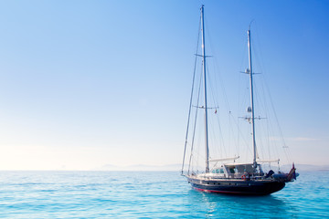 anchored sailboats in turquoise Formentera beach