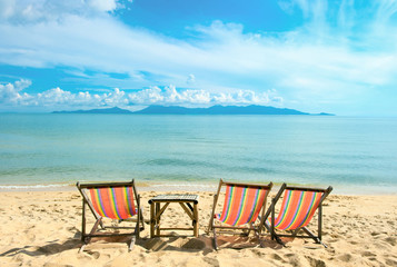 Fototapeta na wymiar Chairs on the sandy beach near with sea