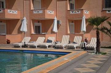 Obraz na płótnie Canvas hotel with swimming pool and sun loungers