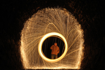 person in a ring burning steel in a dark tunnel