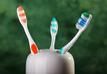 Three colorful toothbrushes in holder
