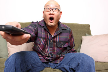 Obraz premium Asian man with remote watching television.